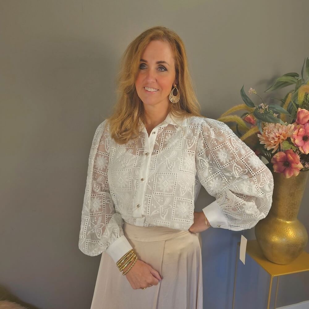 Vrouwelijke blouse in beige, wit en zwart, met bewerkte mouwen en leuke knoopjes.