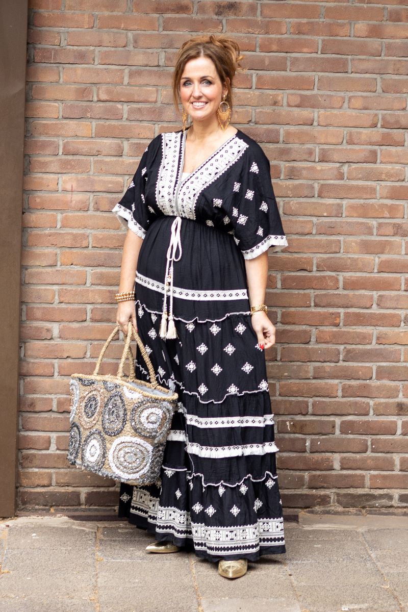 Lange zwarte Ibiza jurk met witte accenten en korte mouwen.