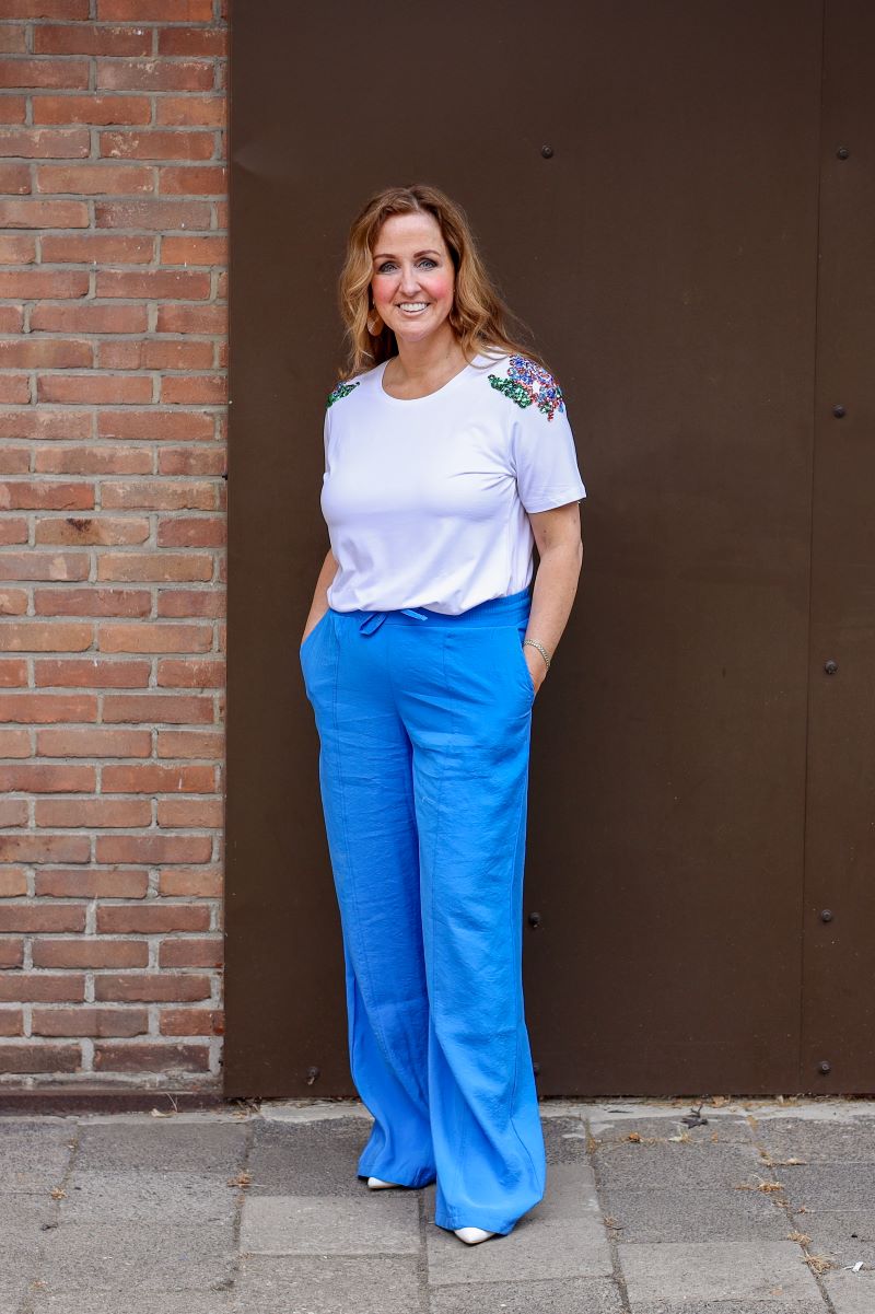 Wit viscose shirt met pailletten op de schouders.